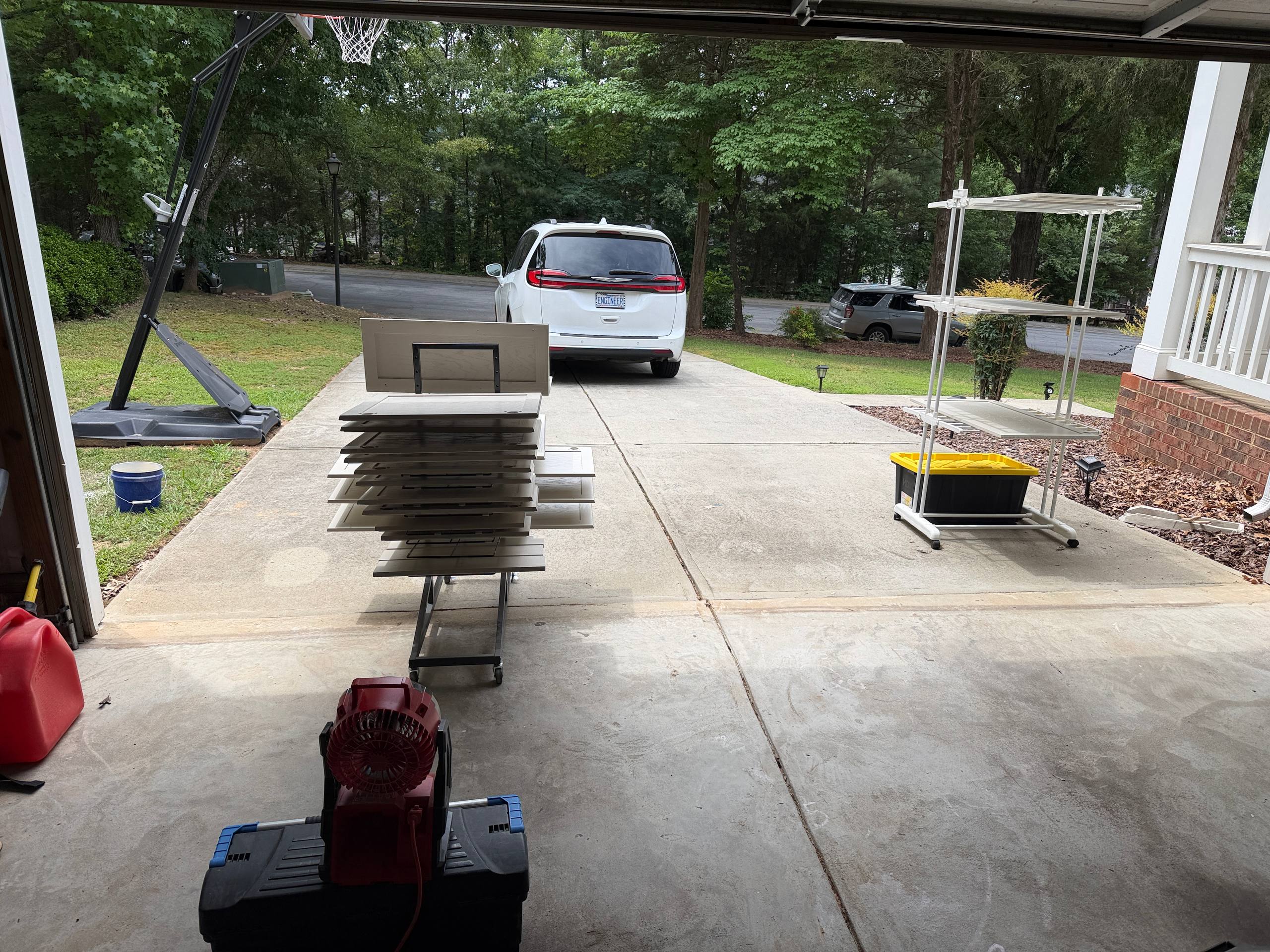 Cabinet doors on driveway spray racks — off-site finishing for drip-free smooth result